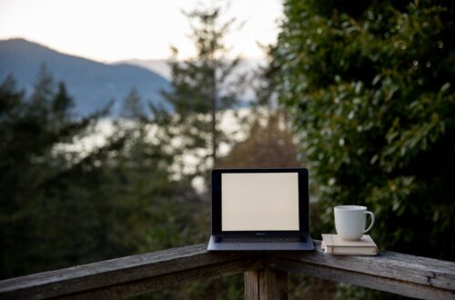 laptop with blank screen and cup of hot drink