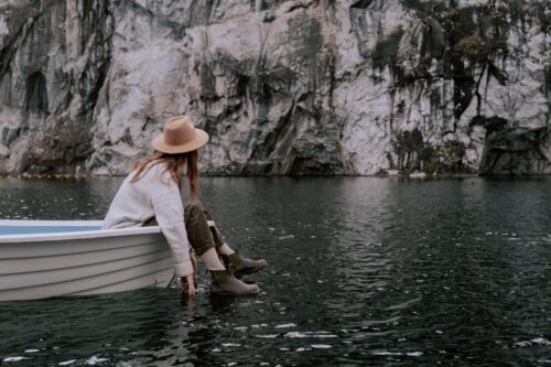a woman sitting on the boat while looking at the rock formation