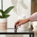 a hand putting the essential oil bottle on the bedside table