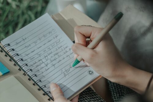 woman writing a note in a journal